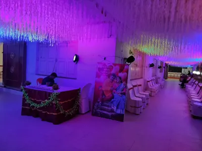 Banquet hall in Behala, Kolkata decorated with cascading floral ceiling, ambient LED lighting, and arranged seating for wedding or reception event