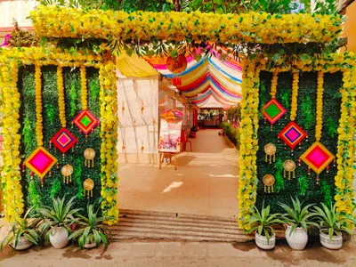 Vibrant wedding venue entrance decorated with yellow marigold flowers, green foliage, and colorful drapes for traditional celebration in Behala, Kolkata