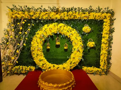 Yellow rose floral backdrop with circular flower arrangement and hanging birdcage decor for wedding or event in Kolkata.
